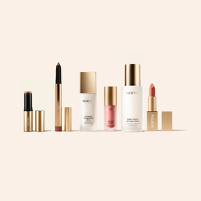 Meroda Cosmetics All-in-One Bundle mit The Soft Tan Bronzer, Eye Perfecting Shimmer Stick, Changing Foundation, Vibrant Cheek Blush, Final Touch Setting Spray und Velvet Dream Lipstick auf einem hellen Hintergrund