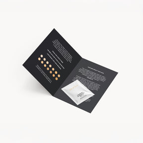 Changing Foundation Sample 1.5 ml Sachet auf schwarzer Broschüre mit Farbmustern und Kundenbewertungen.