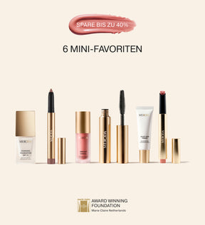 Mini Starter Kit mit Changing Foundation, Mascara, Shimmer Stick, Blush, Primer und Lip Tint auf beigem Hintergrund.