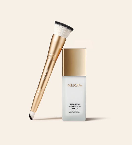 Changing Foundation SPF 15 und 2 in 1 Brush Bundle mit dem Flakon und dem doppelseitigen Pinsel auf hellem Grund.