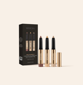 Mini Eye Shimmer Set mit drei goldenen Sticks in Mauve, Champagne und Pearl neben der schwarzen Markenbox.