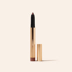 Mauve Eye Perfecting Shimmer Stick in eleganter goldener Hülse mit Deckel auf minimalistischem, cremefarbenem Hintergrund.