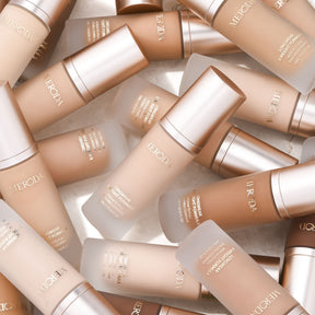 Meroda Cosmetics Universal Foundation Flaschen in verschiedenen Nuancen auf einem hellen Hintergrund