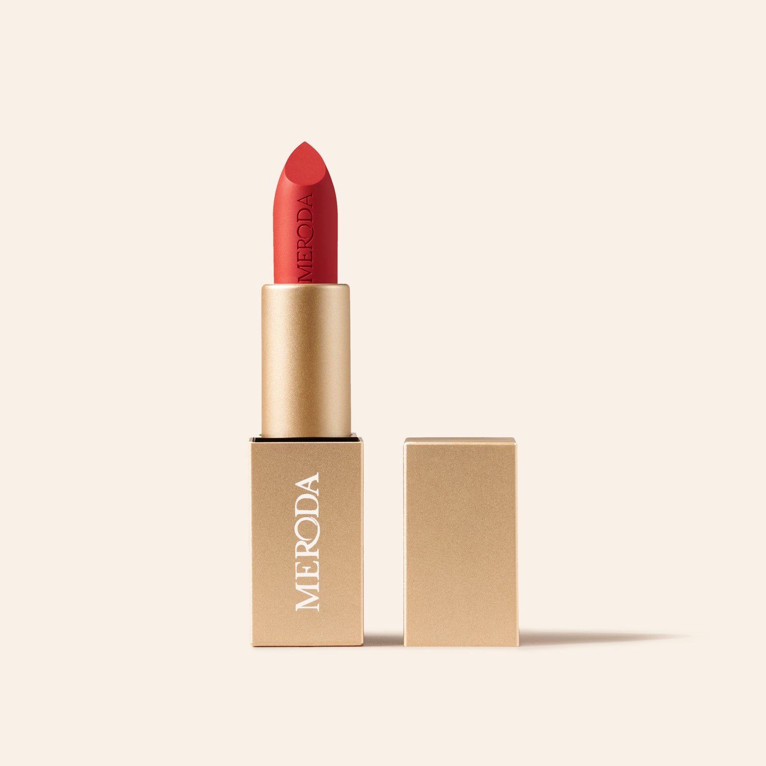 Meroda Velvet Dream Lipstick in Luscious Red mit geöffneter goldener Verpackung auf hellem Hintergrund