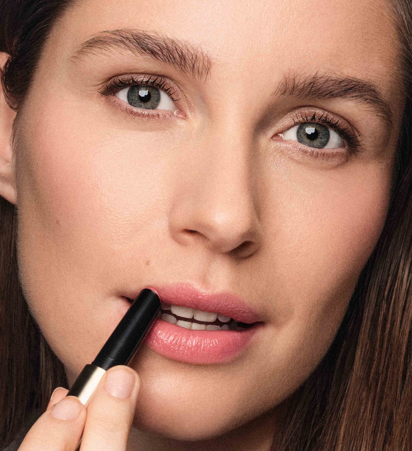 Model trägt Hydrating Lip Tint in Peachy Rose aus dem Sunkissed Trio für einen natürlichen Glanz auf.