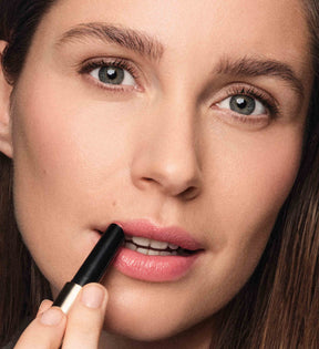 Model trägt Hydrating Lip Tint in Peachy Rose aus dem Sunkissed Trio für einen natürlichen Glanz auf.