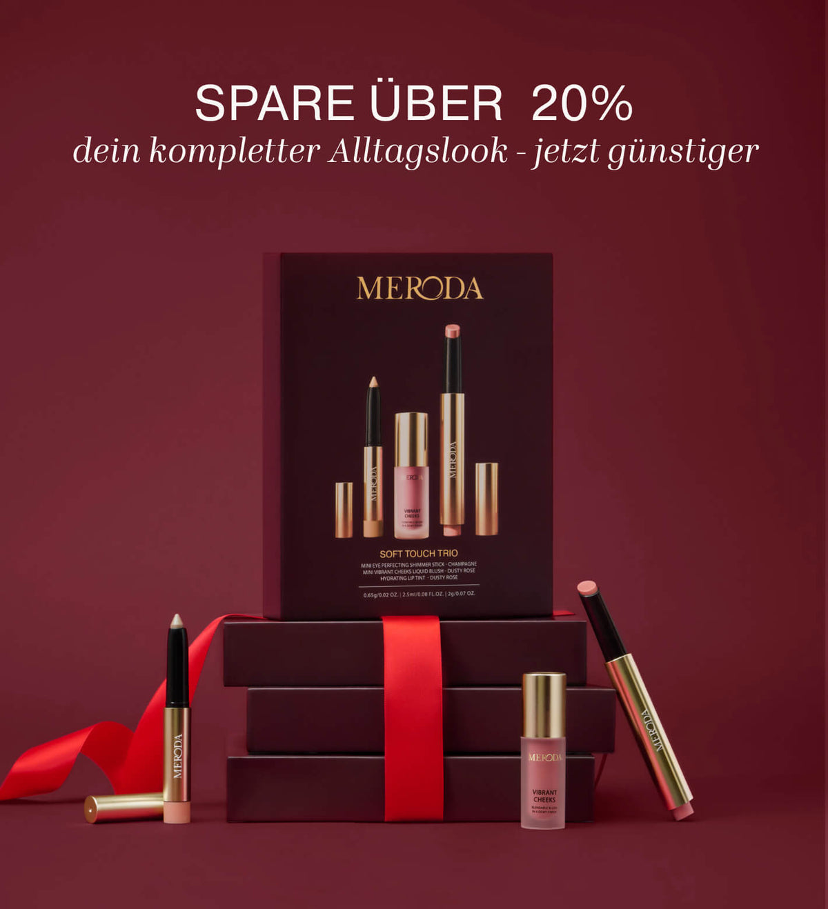 Soft Touch Trio Make-up-Set mit Eye Shimmer Stick, Liquid Blush und Lip Tint vor Geschenkboxen mit rotem Band.