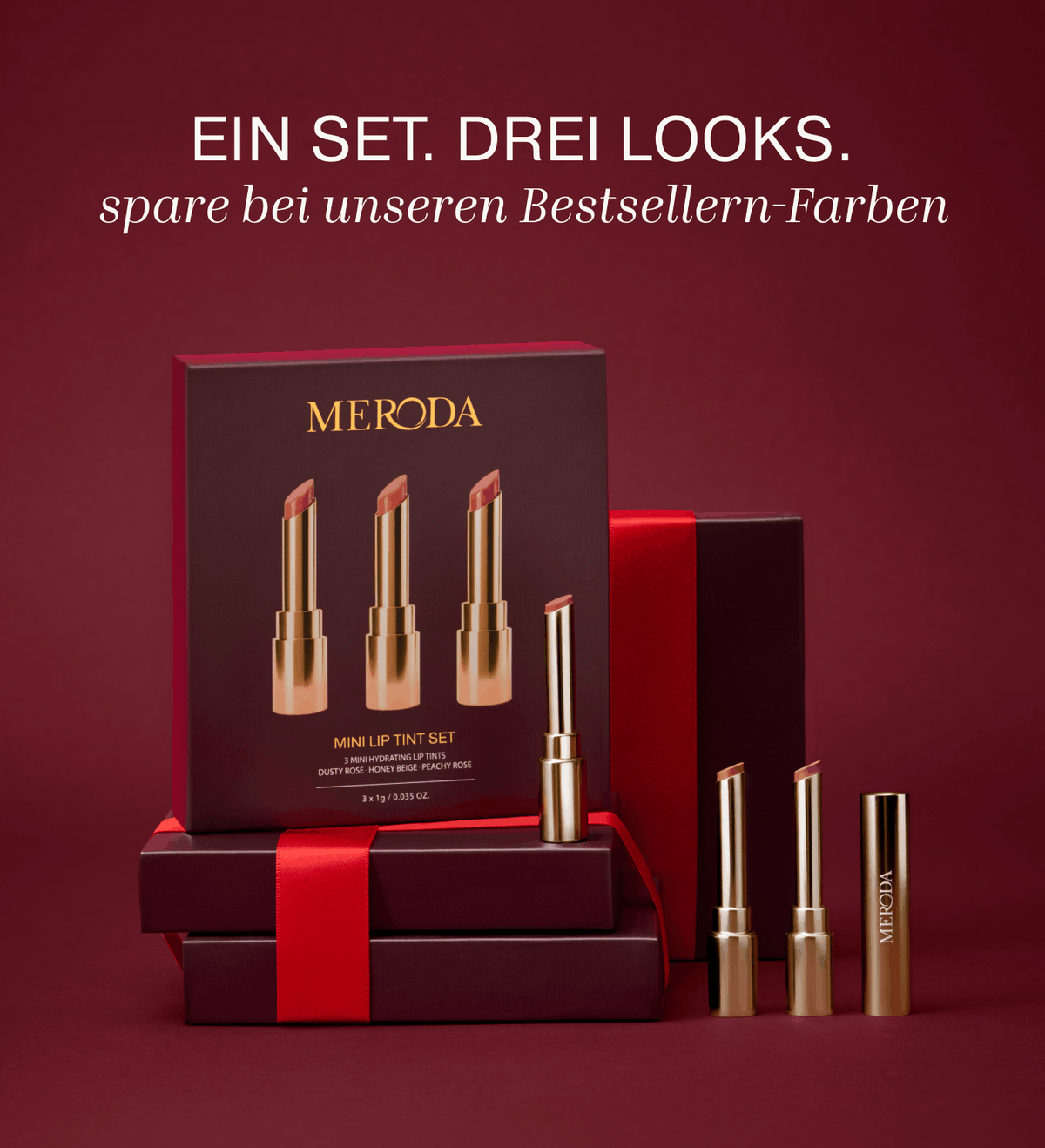 Mini Lip Tint Trio in eleganter Goldverpackung auf dunkelroten Geschenkschachteln.