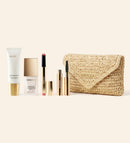 Summer Travel Icons Set mit Daily Face LSF 40, Changing Foundation, Mascara, Lip Tint und beiger Raffia-Clutch.